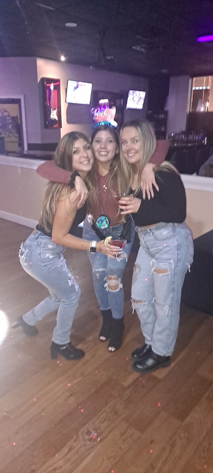 Three women posing for a picture in a club.